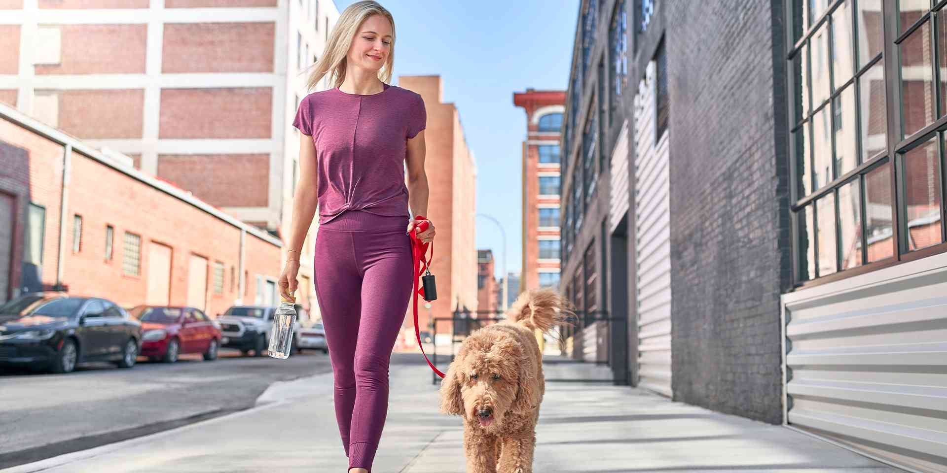 Hay beneficios en el cuerpo de un tutor al tener un perro. Mujer paseando a su mascota.