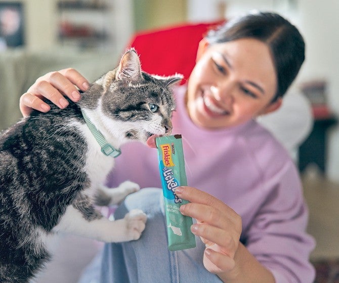 Mujer le da un snack a su gato