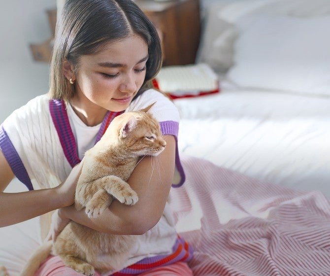 Joven abraza a su gato en casa