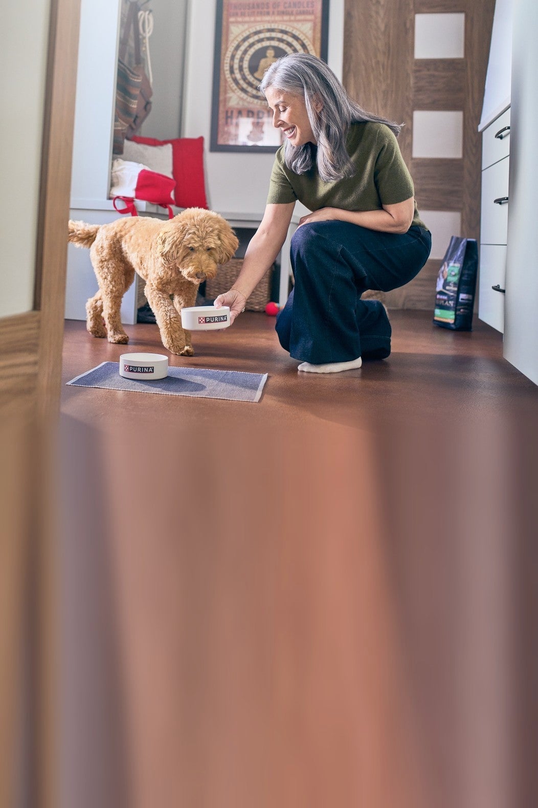 Mujer sirve el alimento a su perro en casa