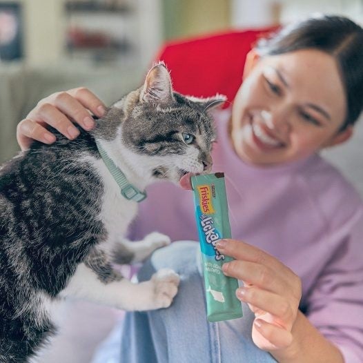 Mujer le da un snack a su gato