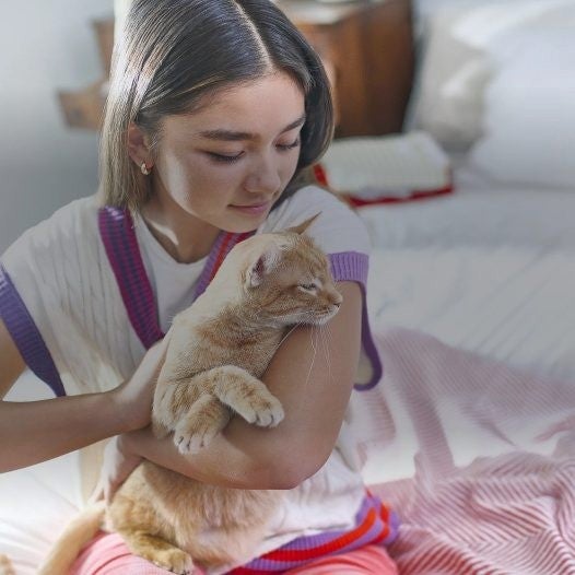 Joven abraza a su gato en casa