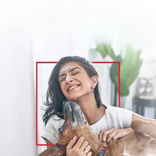 Una mujer abraza a su perro en casa
