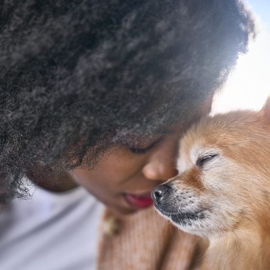 Mujer acerca su rostro al de su perro