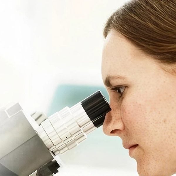 Especialista observa por un microscopio