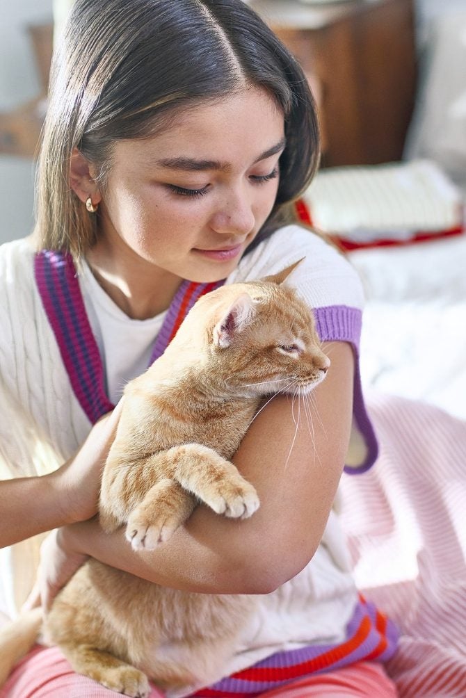 Joven abraza a su gato en casa