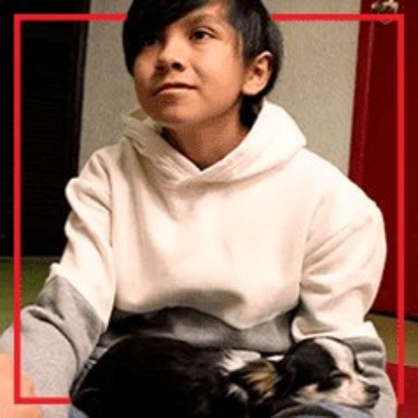 Carlos con un perro de terapia en su regazo