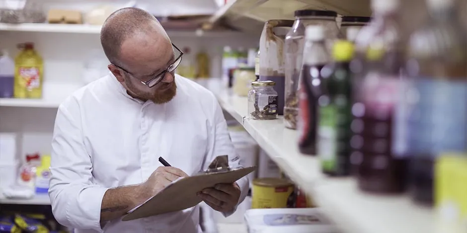 Aprende lo necesario para hacer un adecuado almacenamiento de alimentos. Hombre verificando bodega.